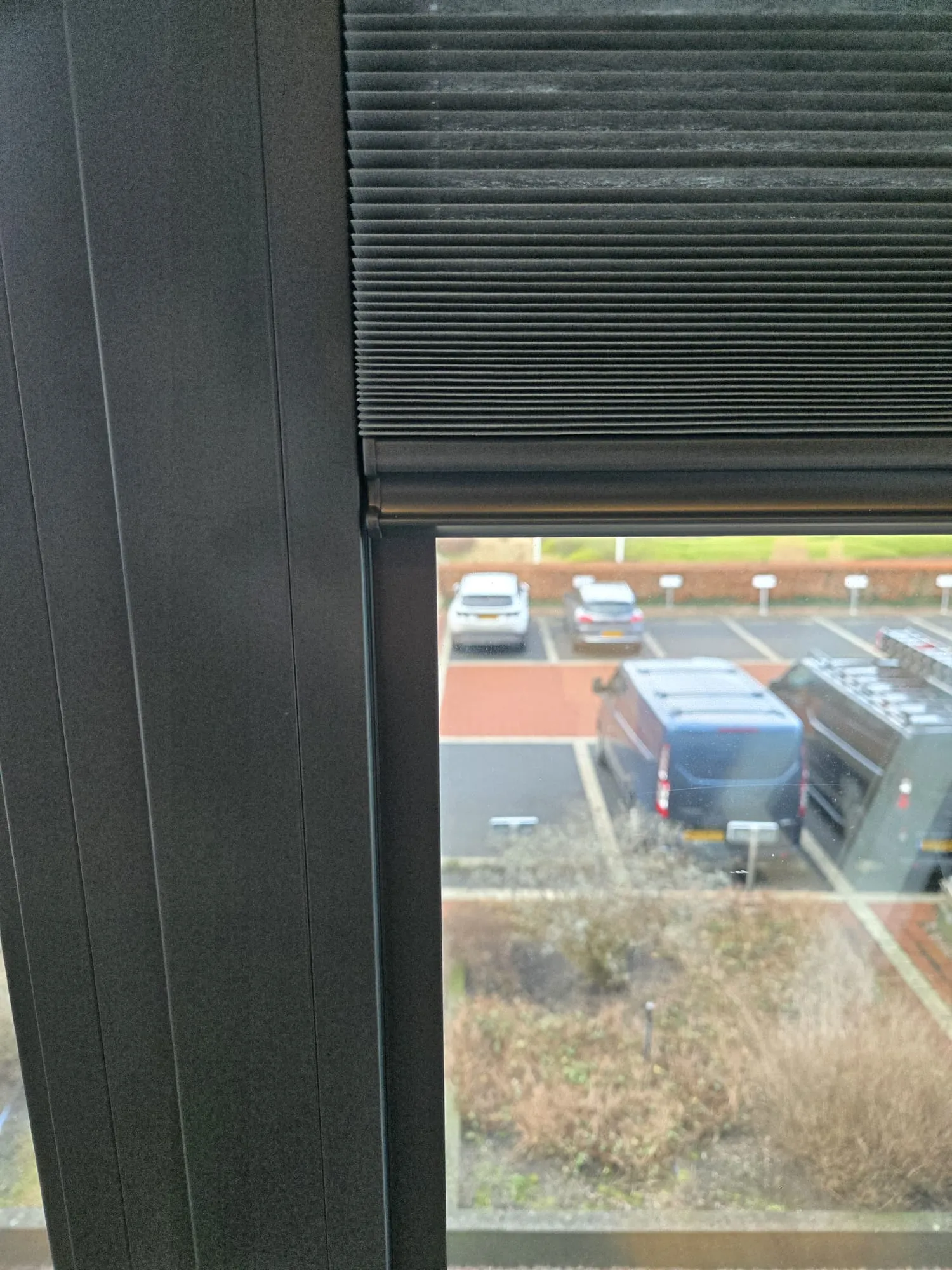 Antraciet plisségordijn strak in het kozijn gemonteerd