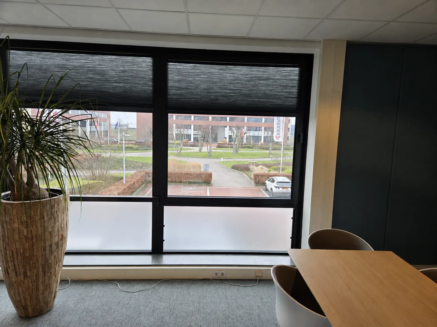 Plisségordijnen met het bovenste deel gesloten tegen de zon, terwijl het uitzicht naar buiten behouden blijft