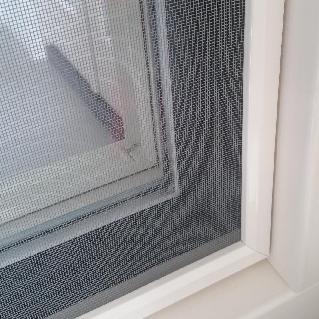 Inzethor met klemveren gemonteerd in een kozijn, close-up van de hoek