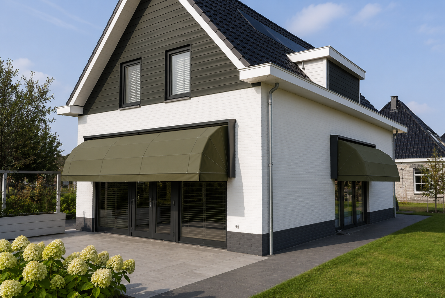 Woning met twee groene markiezen boven de terrasdeuren
