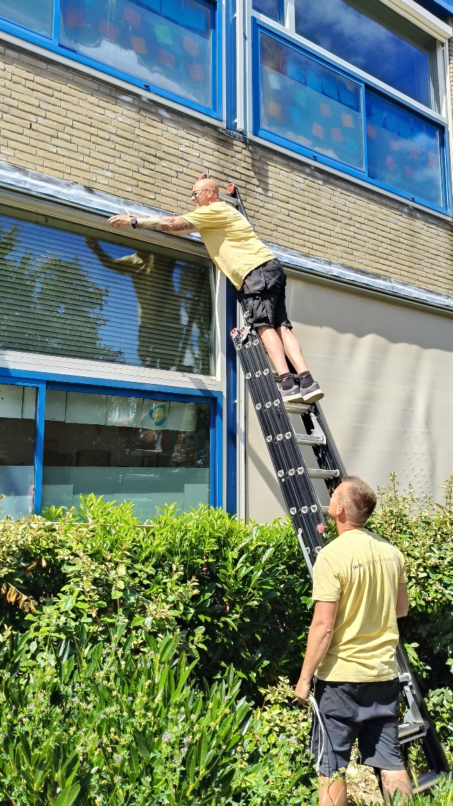 Monteurs van IWS Zonwering tijdens onderhoud aan zonwering bij een schoolgebouw